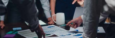 Millennial Asia businessmen and businesswomen meeting brainstorming ideas about new paperwork project colleagues working together planning success strategy enjoy teamwork in small modern night office.